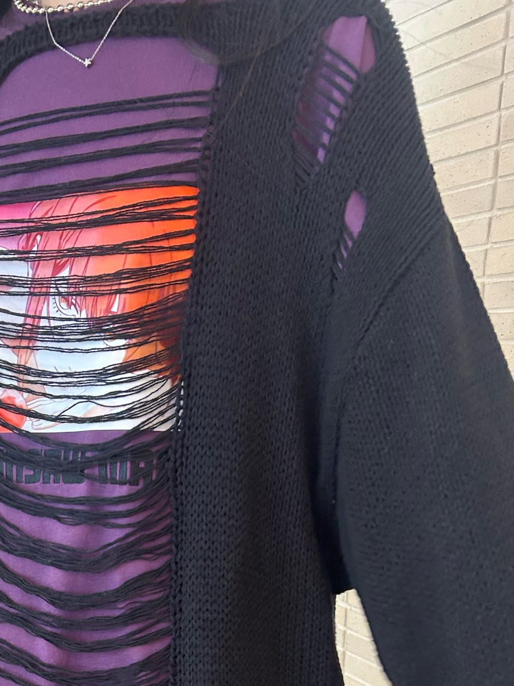 ブラック系のニット/セーター、パープル系のTシャツ/カットソー、ブラック系のスカートを着用したレディースの秋コーディネートの6枚目の写真