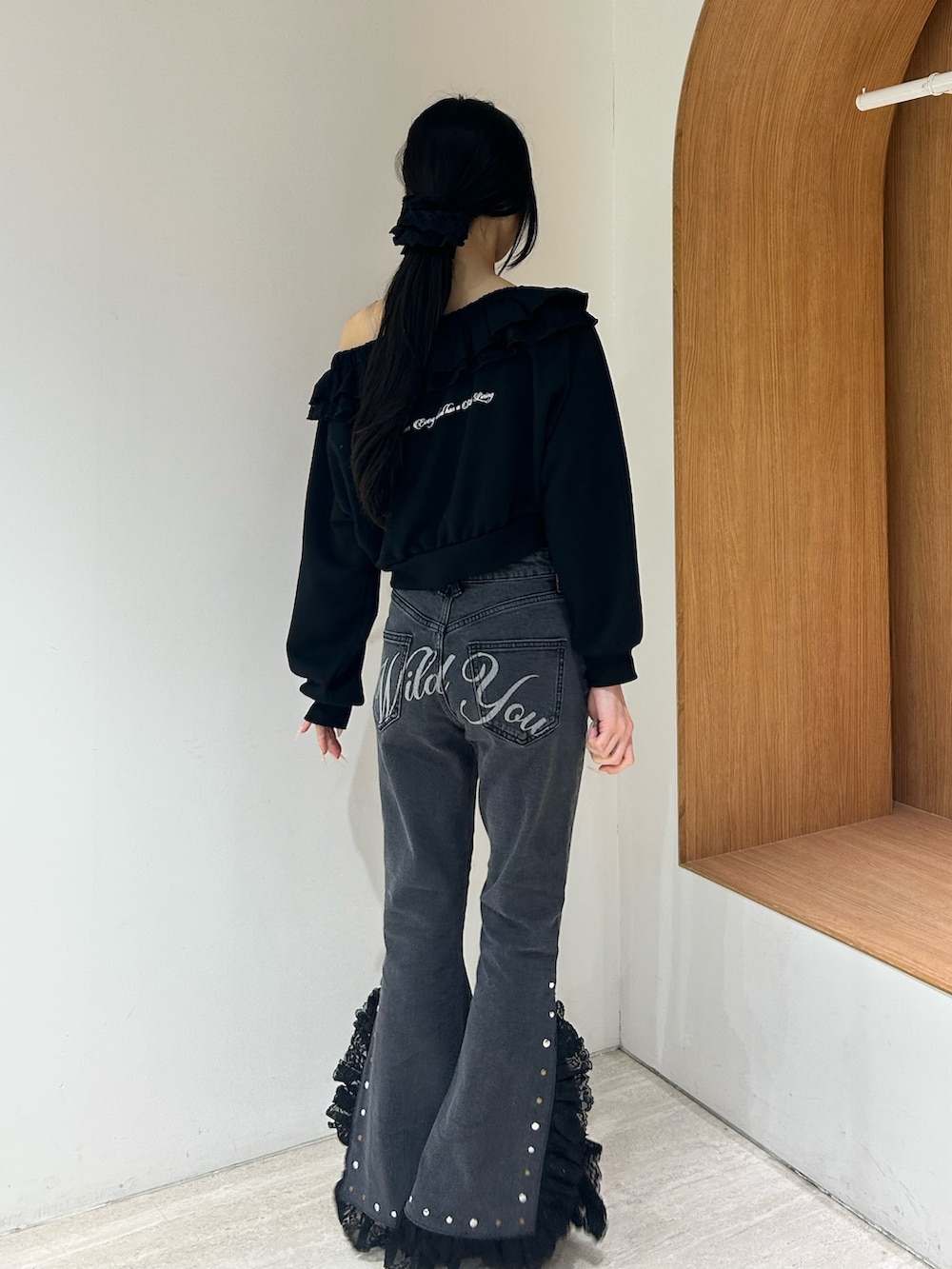 ブラック系のスウェット、ブラック系のデニムパンツ、ブラック系のパンプスを着用したレディースの冬コーディネートの3枚目の写真