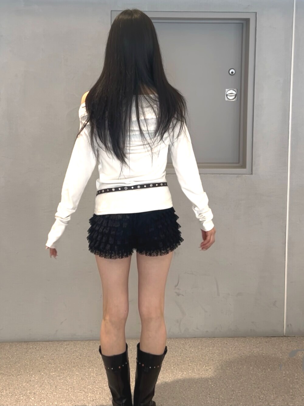 ブラック系のその他パンツ、ブラック系のブーツ、ホワイト系のTシャツ/カットソーを着用したレディースの春コーディネートの3枚目の写真