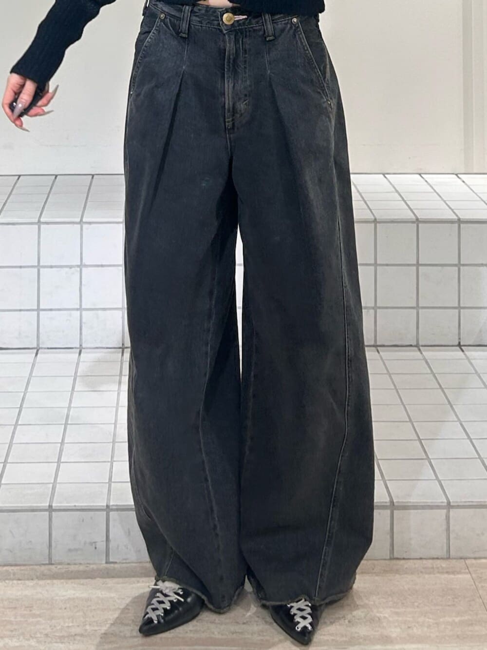 ブラック系のパンプス、ブルー系のデニムパンツ、イエロー系のパーカーを着用したレディースの冬コーディネートの6枚目の写真