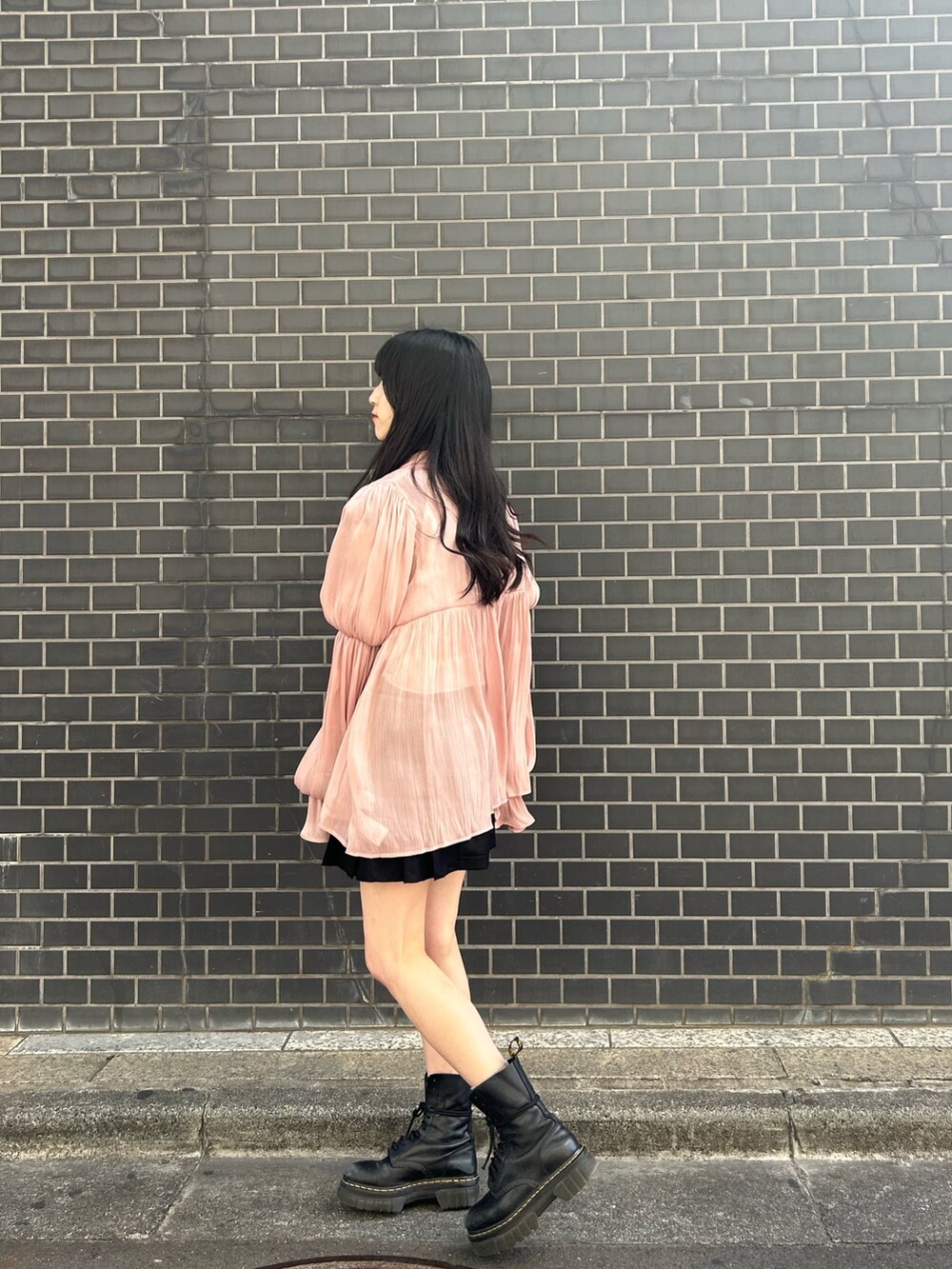 ピンク系のシャツ/ブラウス、ホワイト系のニット/セーター、ブラック系のスカートを着用したレディースの春コーディネートの3枚目の写真