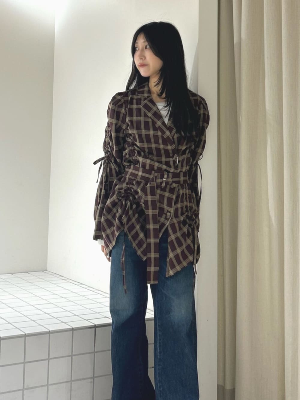 ブラック系のパンプス、レッド系のワンピース、ブルー系のデニムパンツを着用したレディースの秋コーディネートの4枚目の写真