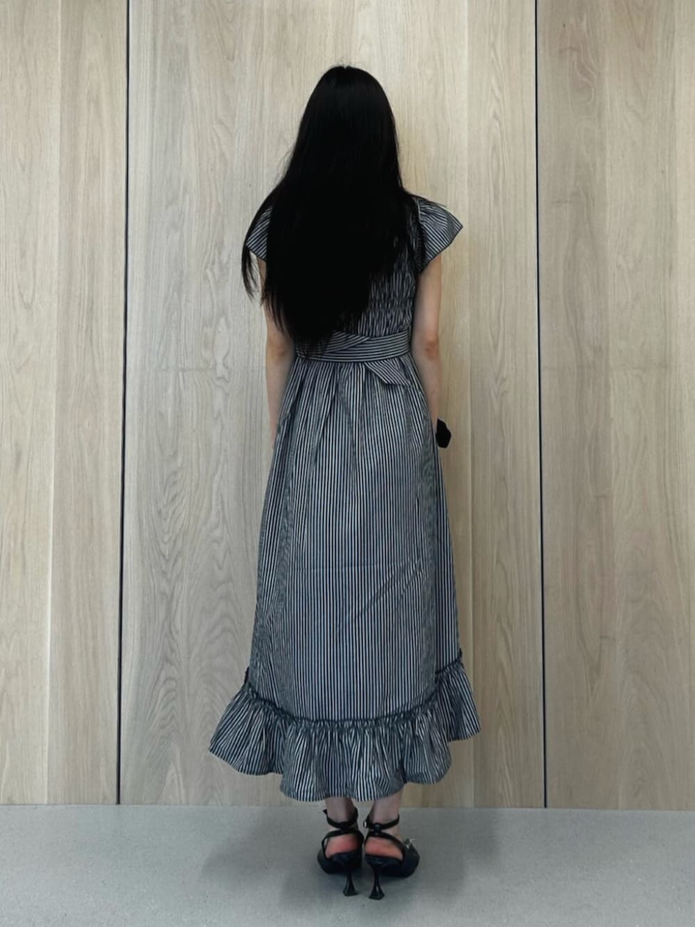 ブラック系のパンプス、ブラック系のワンピースを着用したレディースの夏コーディネートの3枚目の写真