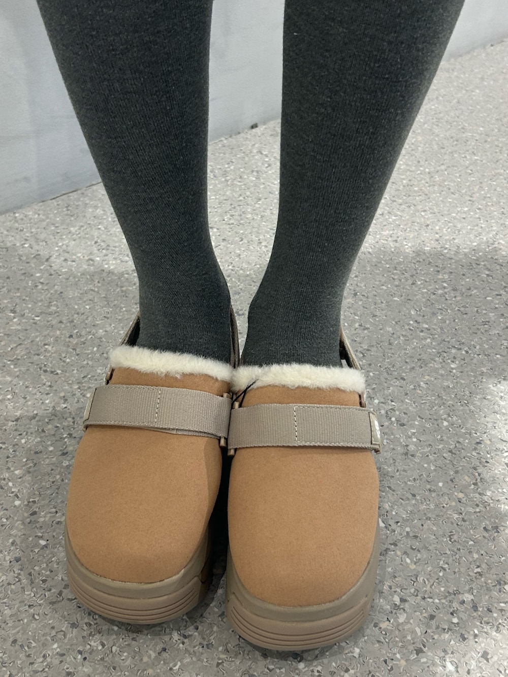 ホワイト系のショルダーバッグ、ベージュ系のブーツ、ブラウン系のスカートを着用したレディースの秋コーディネートの9枚目の写真