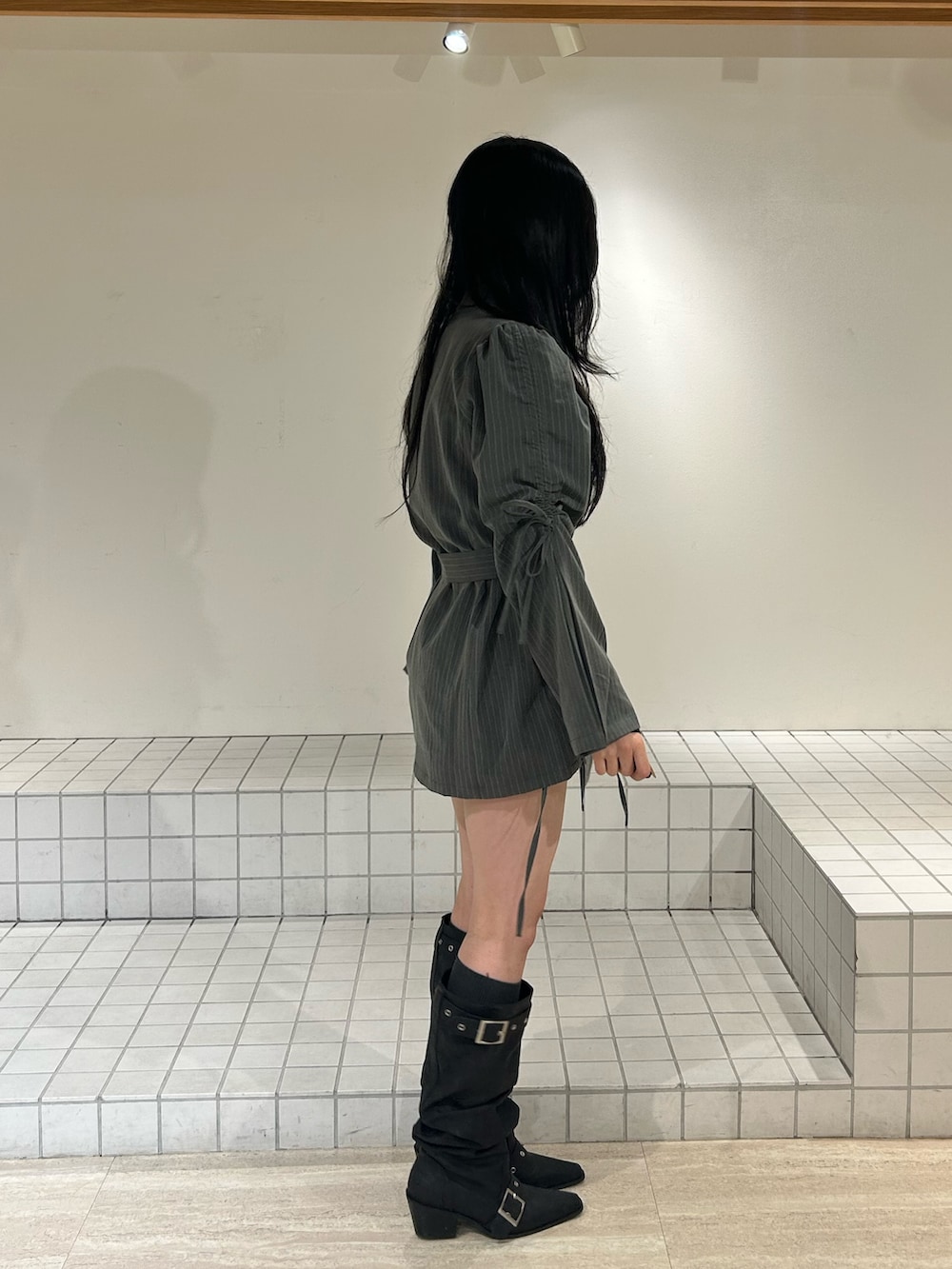 ブラック系のブーツ、グレー系のテーラードジャケット、ブラック系のニット/セーターを着用したレディースの冬コーディネートの2枚目の写真