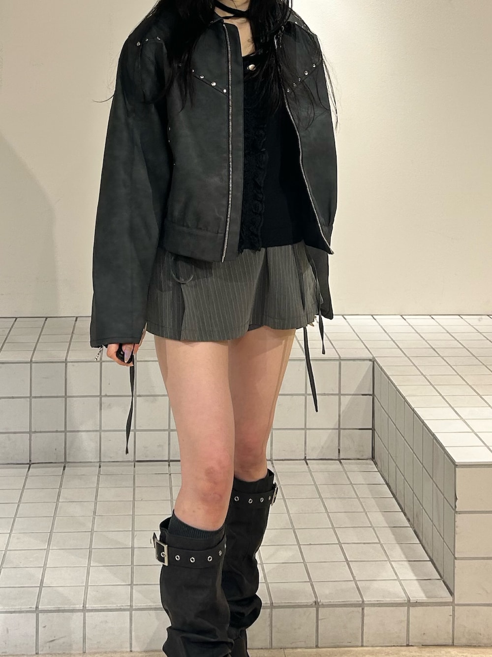 ブラック系のブーツ、グレー系のスカート、ブラック系のブルゾンを着用したレディースの冬コーディネートの5枚目の写真