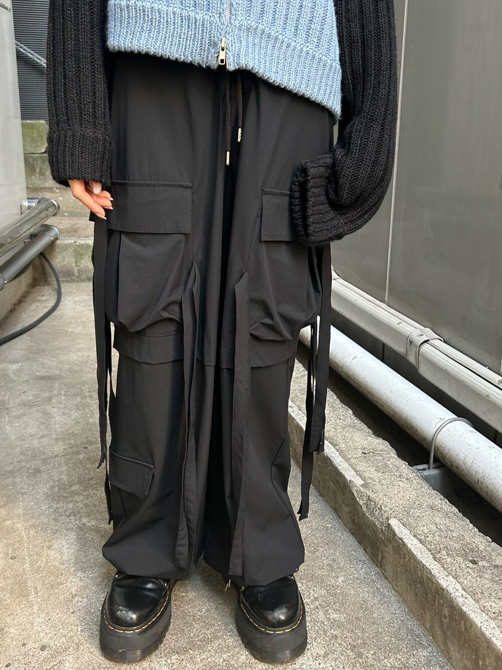 ブラック系のニット/セーター、ブラック系のその他パンツ、ブラック系のキャップを着用したレディースの秋コーディネートの7枚目の写真