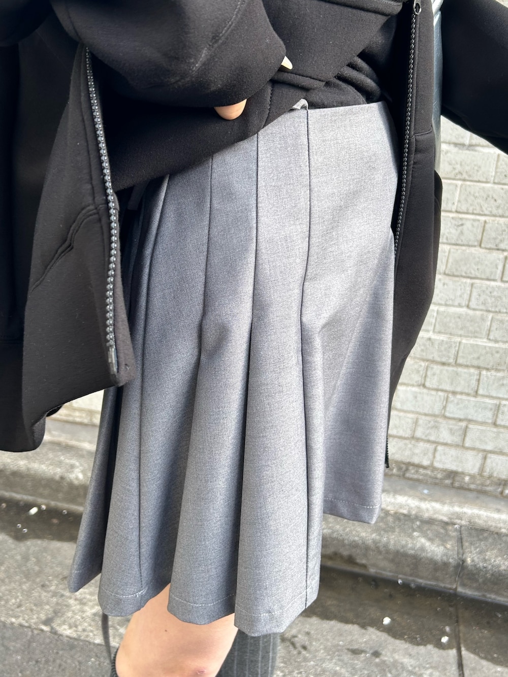 ブラック系のパーカー、グレー系のスカート、シルバー系のショルダーバッグを着用したレディースの冬コーディネートの6枚目の写真