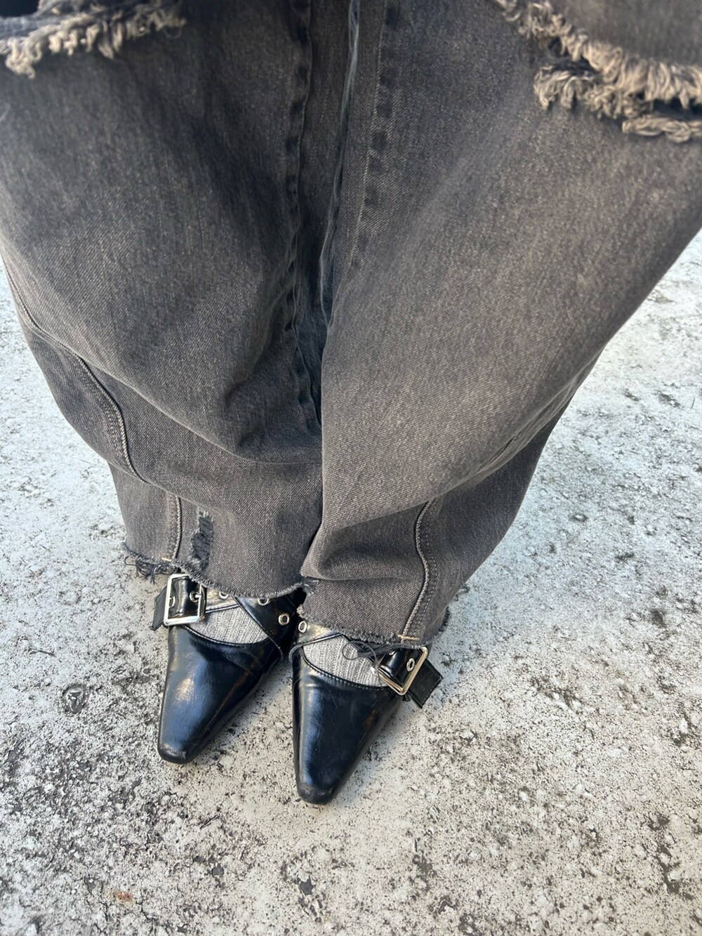 ブラック系のデニムパンツ、ブラック系のスウェット、ブラック系のパンプスを着用したレディースの冬コーディネートの8枚目の写真