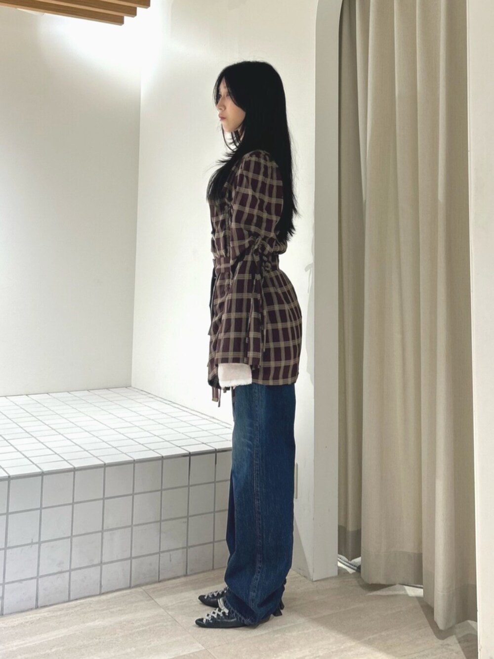 ブラック系のパンプス、レッド系のワンピース、ブルー系のデニムパンツを着用したレディースの秋コーディネートの2枚目の写真