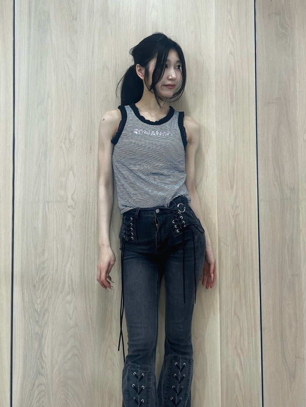 ブラック系のデニムパンツ、ブラック系のパンプス、その他のタンクトップを着用したレディースの春コーディネートの4枚目の写真