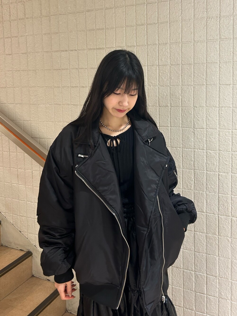 ブラック系のMA-1、ブラック系のニット/セーター、ブラック系のスカートを着用したレディースの冬コーディネートの3枚目の写真