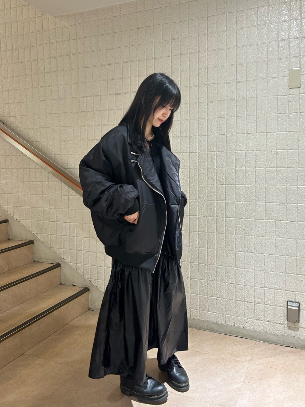 ブラック系のMA-1、ブラック系のニット/セーター、ブラック系のスカートを着用したレディースの冬コーディネートの2枚目の写真