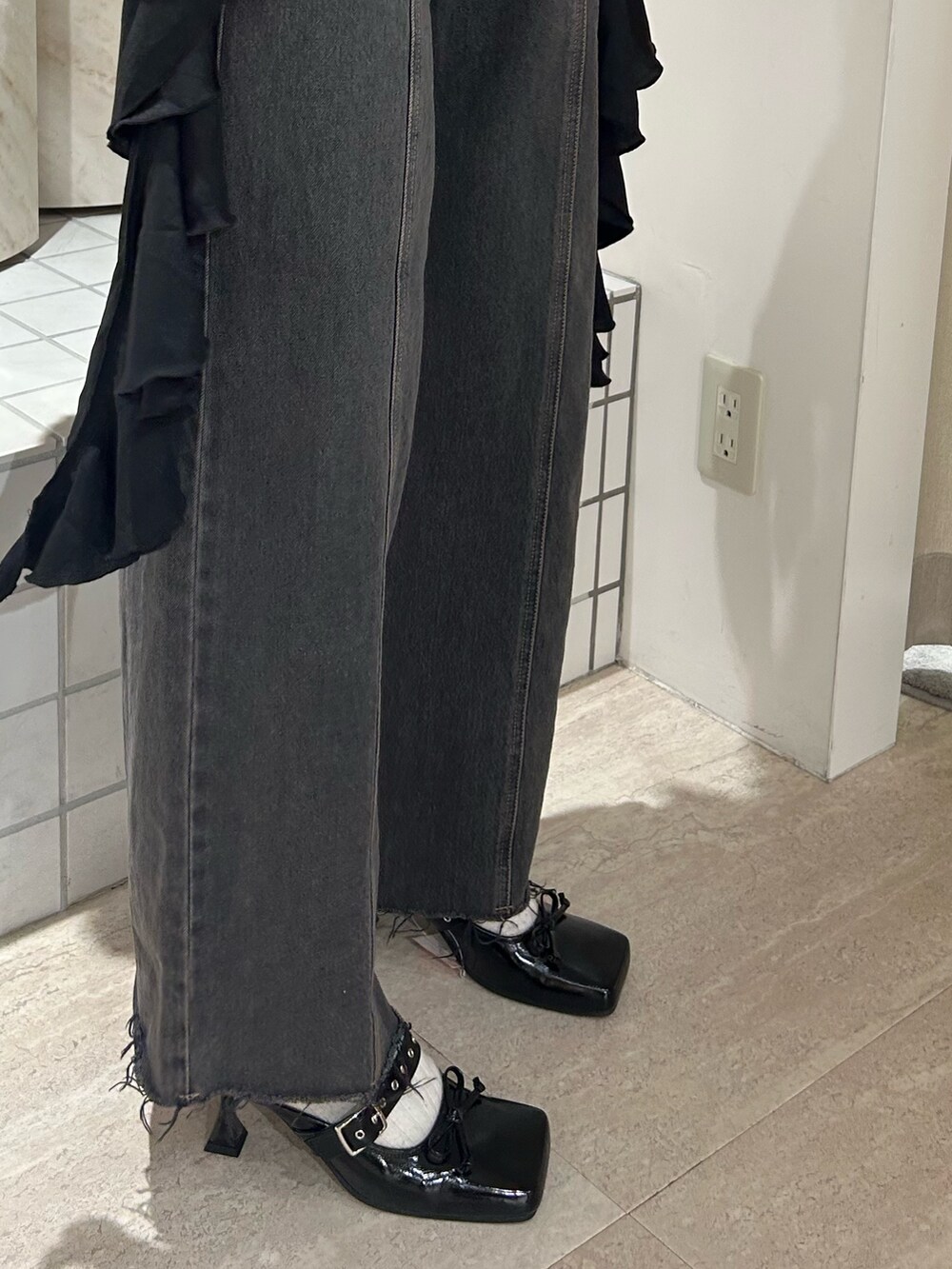 ブラック系のキャミソール、ブラック系のTシャツ/カットソー、ブラック系のデニムパンツを着用したレディースの春コーディネートの8枚目の写真