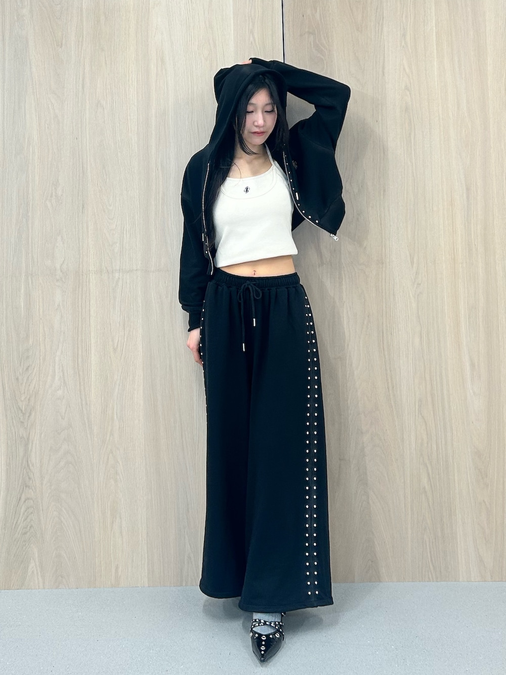 ブラック系のパーカー、ブラック系のスウェットパンツ、ブラック系のパンプスを着用したレディースの春コーディネートの5枚目の写真