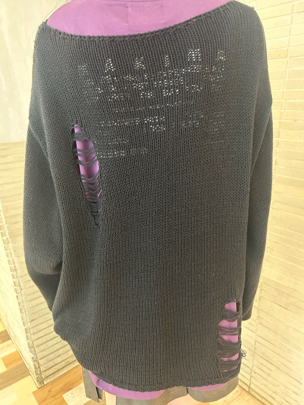 ブラック系のニット/セーター、パープル系のTシャツ/カットソー、ブラック系のスカートを着用したレディースの秋コーディネートの8枚目の写真