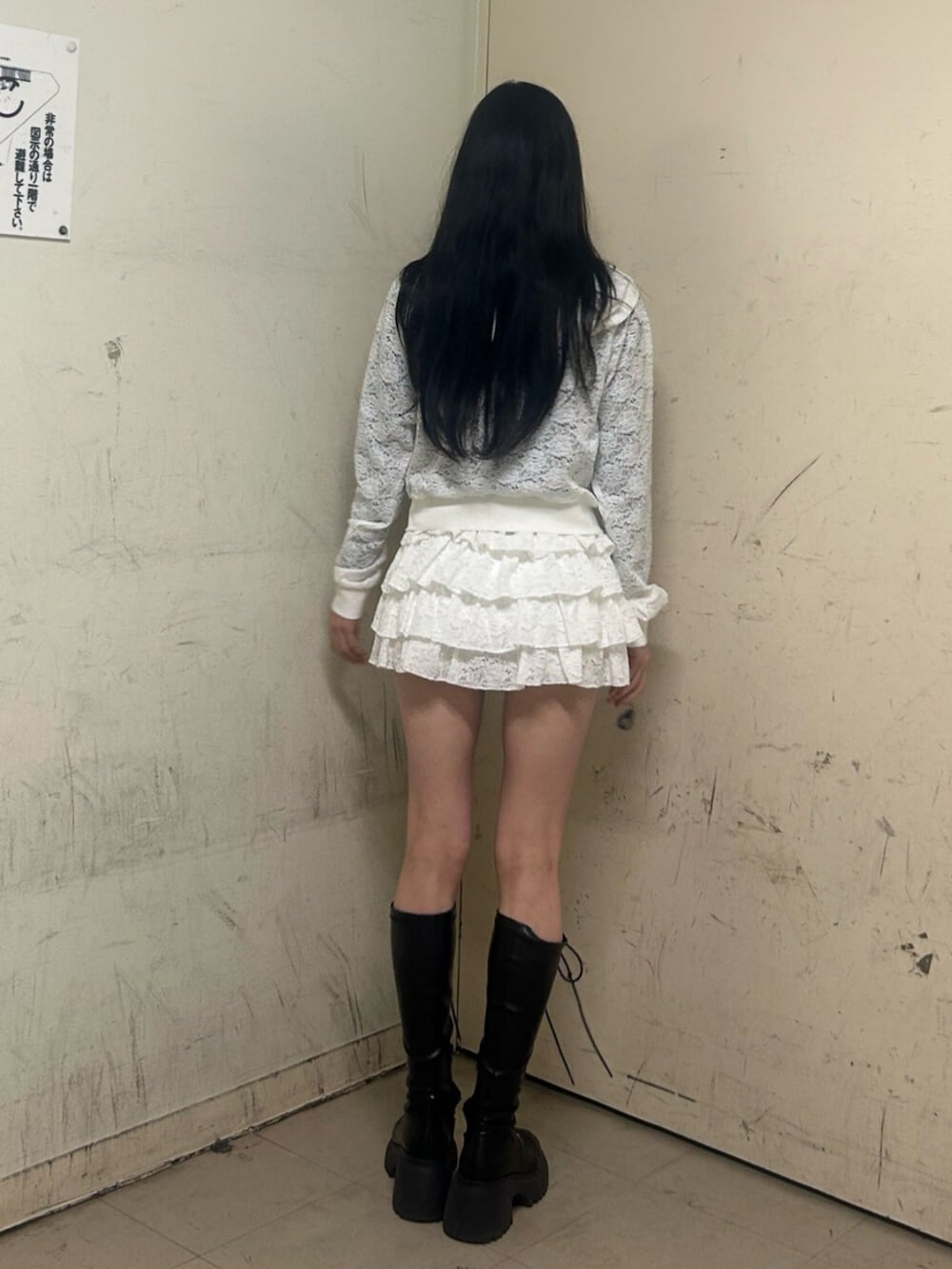 ブラック系のブーツ、ホワイト系のパーカー、ホワイト系のスカートを着用したレディースの春コーディネートの3枚目の写真