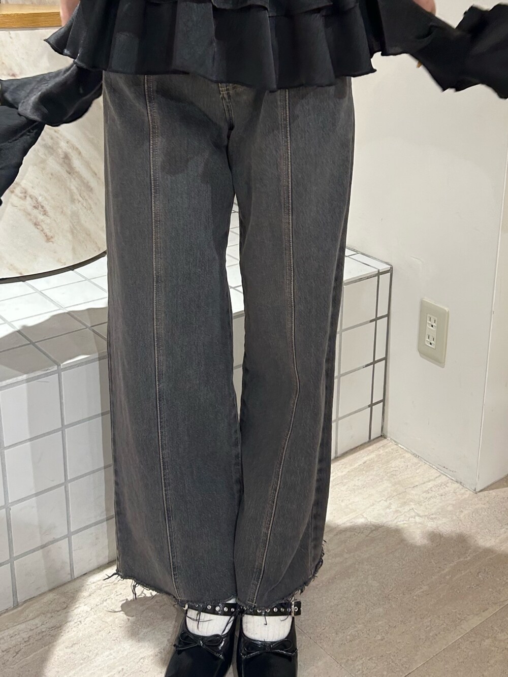 ブラック系のキャミソール、ブラック系のTシャツ/カットソー、ブラック系のデニムパンツを着用したレディースの春コーディネートの7枚目の写真