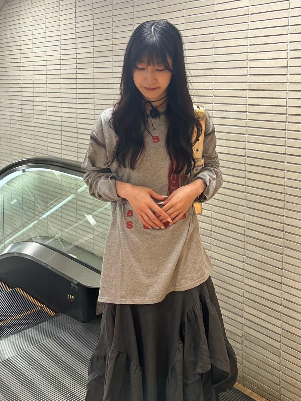 グレー系のTシャツ/カットソー、グレー系のスカート、ブラック系のパンプスを着用したレディースの夏コーディネートの4枚目の写真