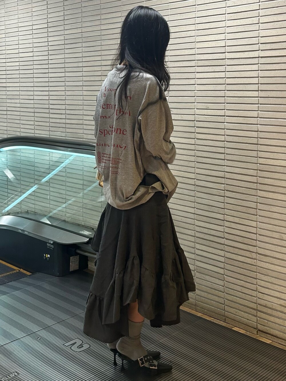 グレー系のTシャツ/カットソー、グレー系のスカート、ブラック系のパンプスを着用したレディースの夏コーディネートの2枚目の写真