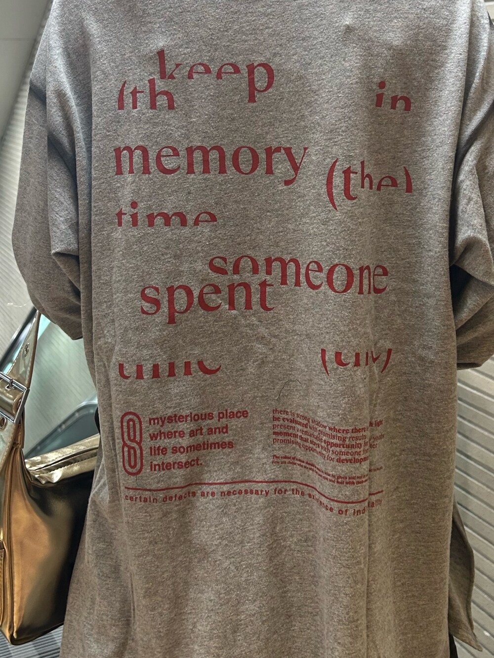 グレー系のTシャツ/カットソー、グレー系のスカート、ブラック系のパンプスを着用したレディースの夏コーディネートの7枚目の写真