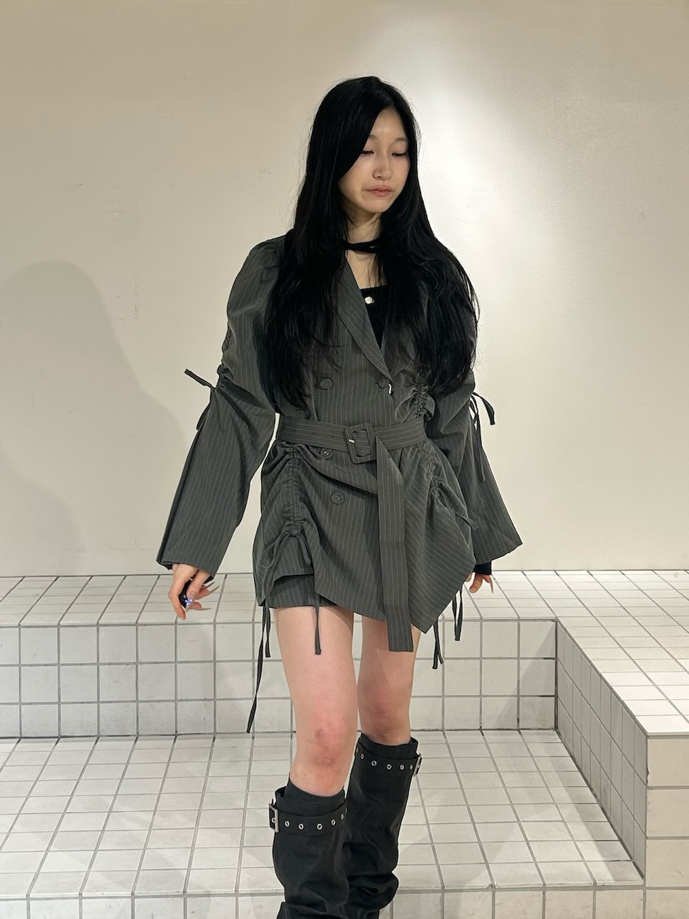 ブラック系のブーツ、グレー系のテーラードジャケット、ブラック系のニット/セーターを着用したレディースの冬コーディネートの4枚目の写真