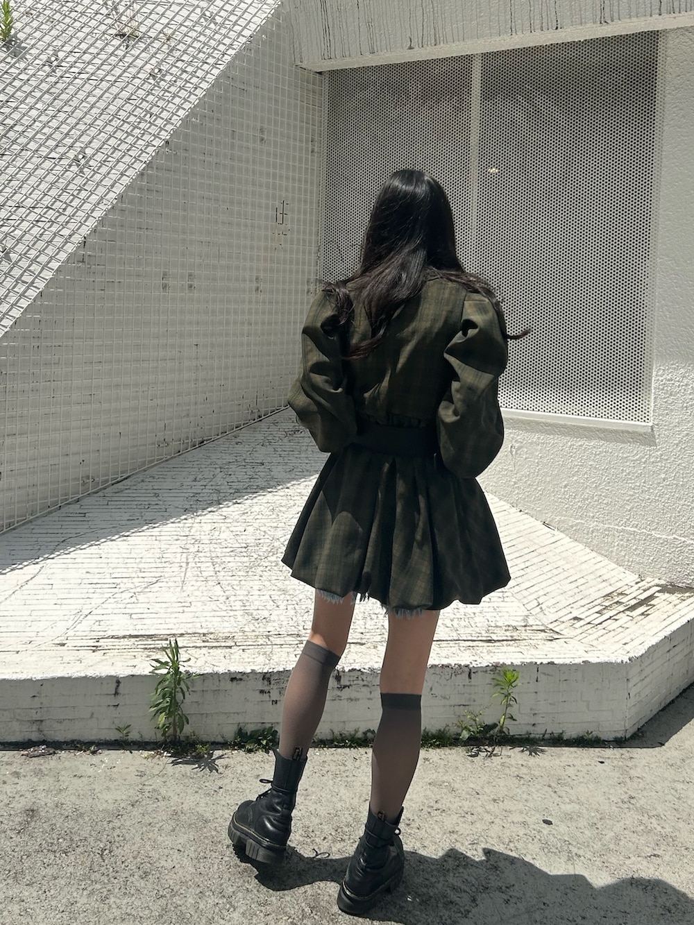 グリーン系のワンピース、ブルー系のデニムパンツ、ブラック系のベルトを着用したレディースの夏コーディネートの2枚目の写真