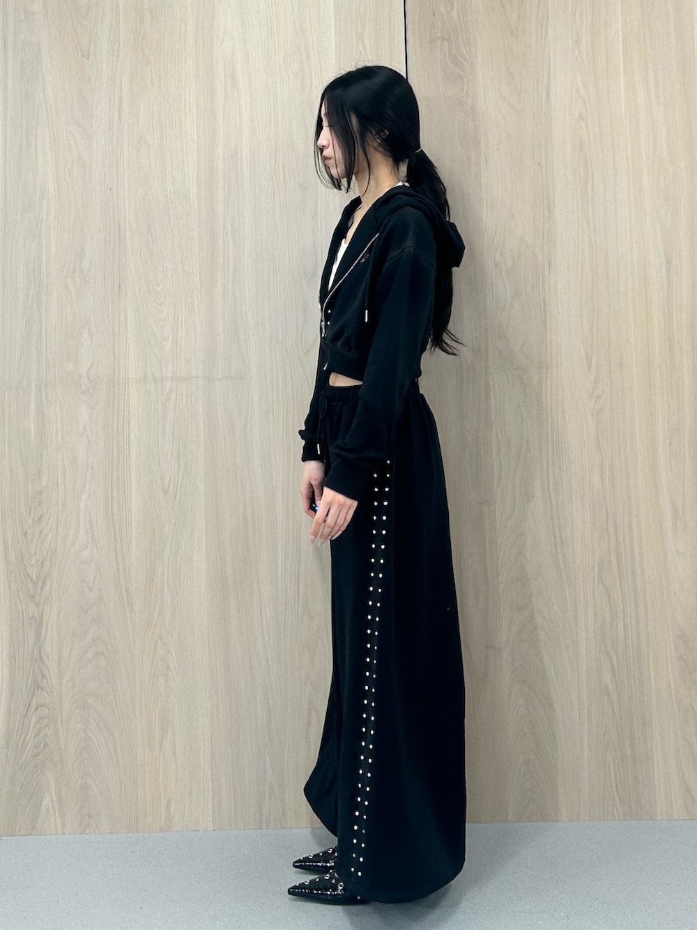 ブラック系のパーカー、ブラック系のスウェットパンツ、ブラック系のパンプスを着用したレディースの春コーディネートの2枚目の写真