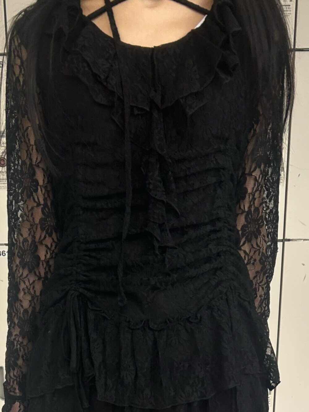 ゴールド系のパンプス、ブラック系のワンピース、ブラック系のデニムパンツを着用したレディースの冬コーディネートの5枚目の写真