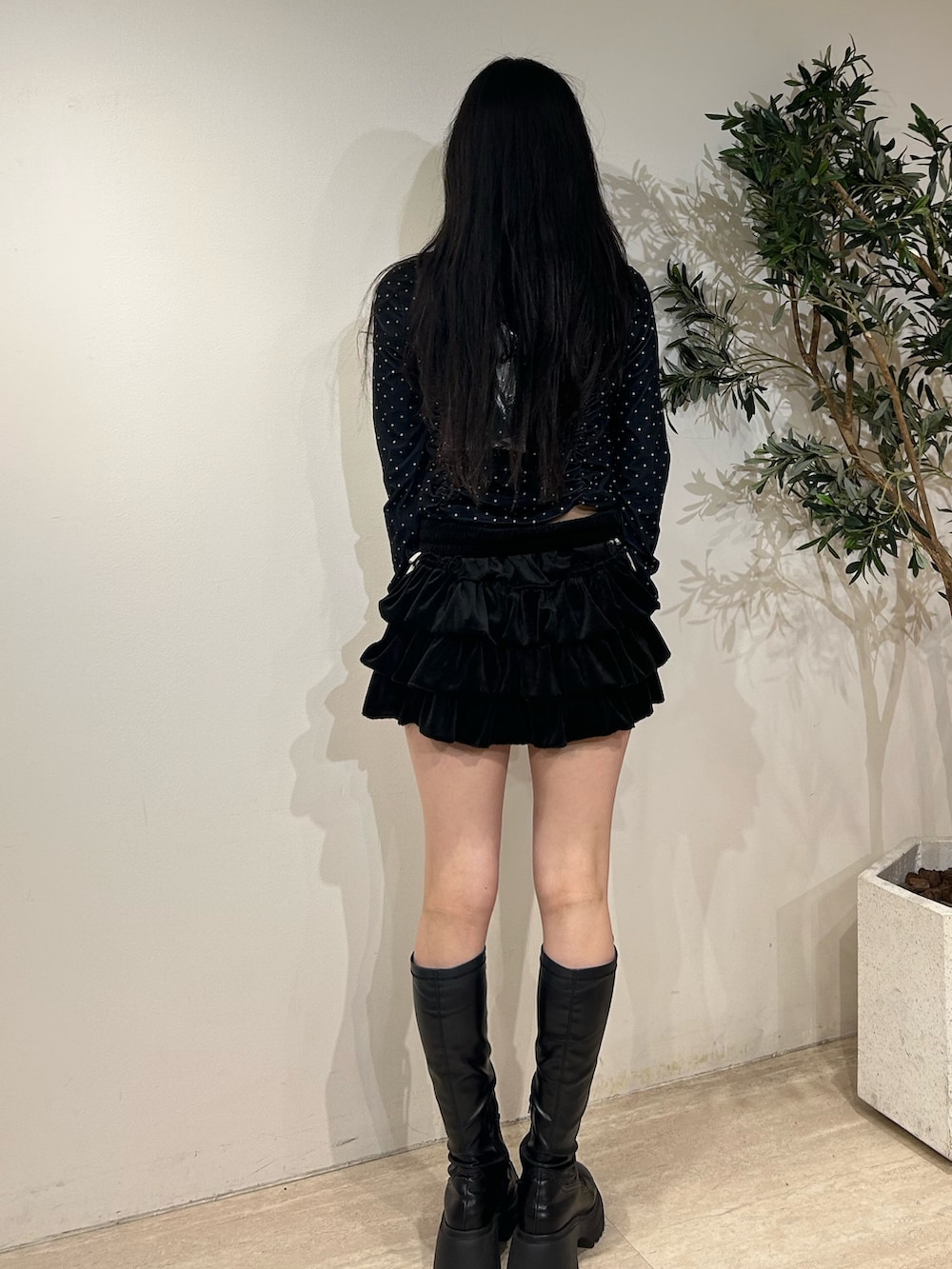 ブラック系のスカート、ブラック系のTシャツ/カットソー、ブラック系のブーツを着用したレディースの秋コーディネートの3枚目の写真