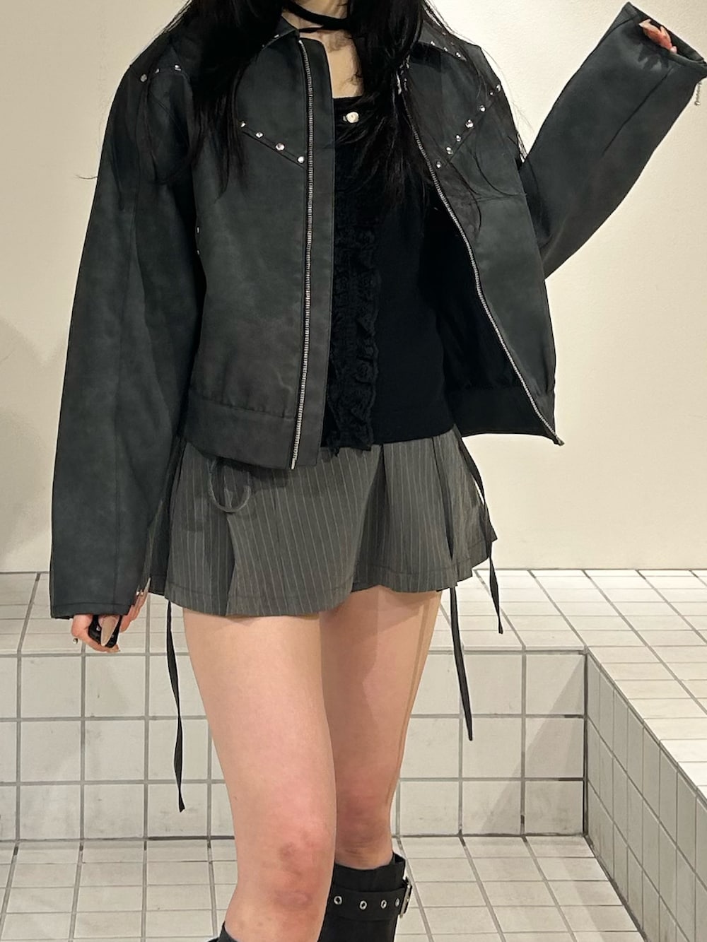 ブラック系のブーツ、グレー系のスカート、ブラック系のブルゾンを着用したレディースの冬コーディネートの6枚目の写真