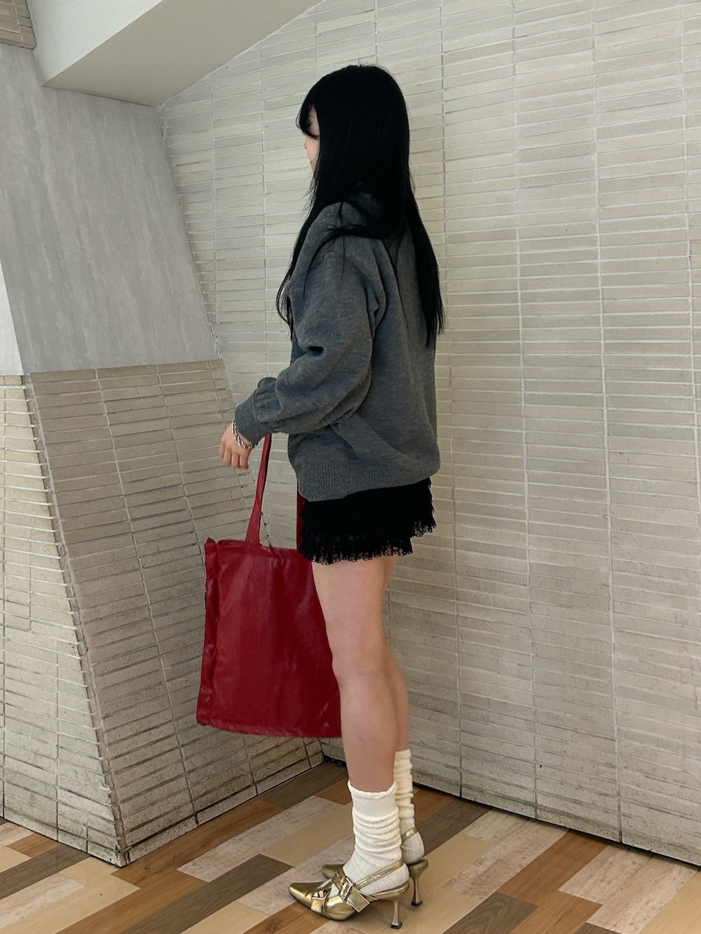 ゴールド系のパンプス、ブラック系のその他パンツ、レッド系のトートバッグを着用したレディースの冬コーディネートの2枚目の写真