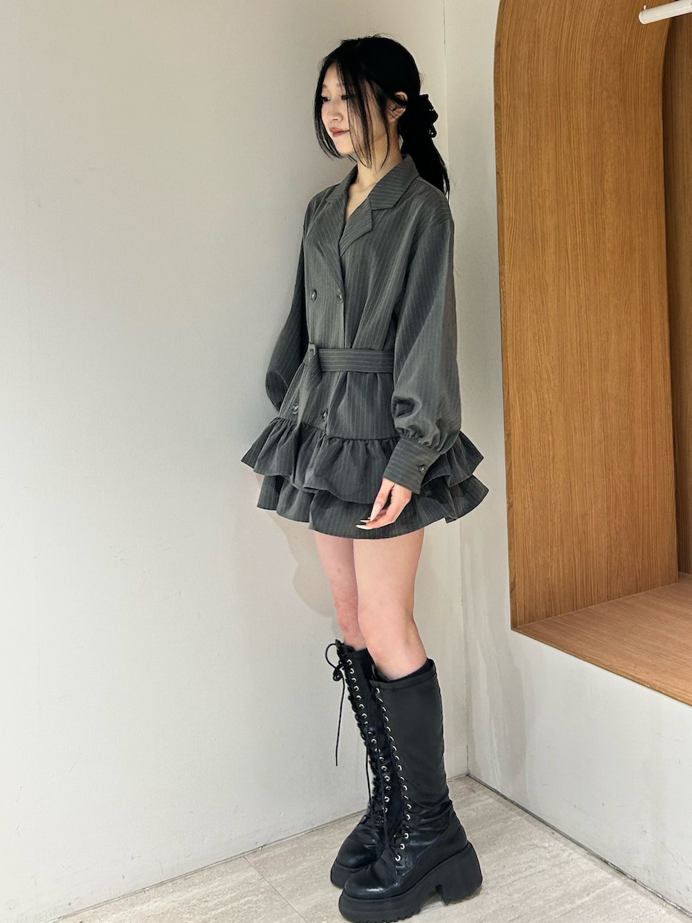 グレー系のワンピース、ブラック系のブーツを着用したレディースの冬コーディネートの2枚目の写真