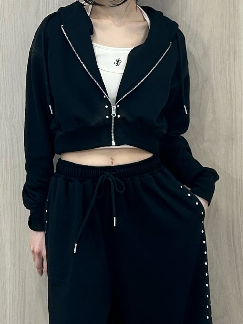 ブラック系のパーカー、ブラック系のスウェットパンツ、ブラック系のパンプスを着用したレディースの春コーディネートの6枚目の写真