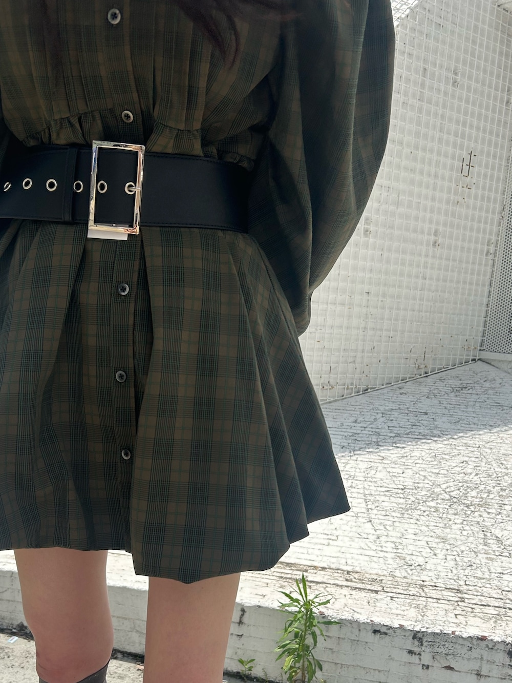 グリーン系のワンピース、ブルー系のデニムパンツ、ブラック系のベルトを着用したレディースの夏コーディネートの6枚目の写真