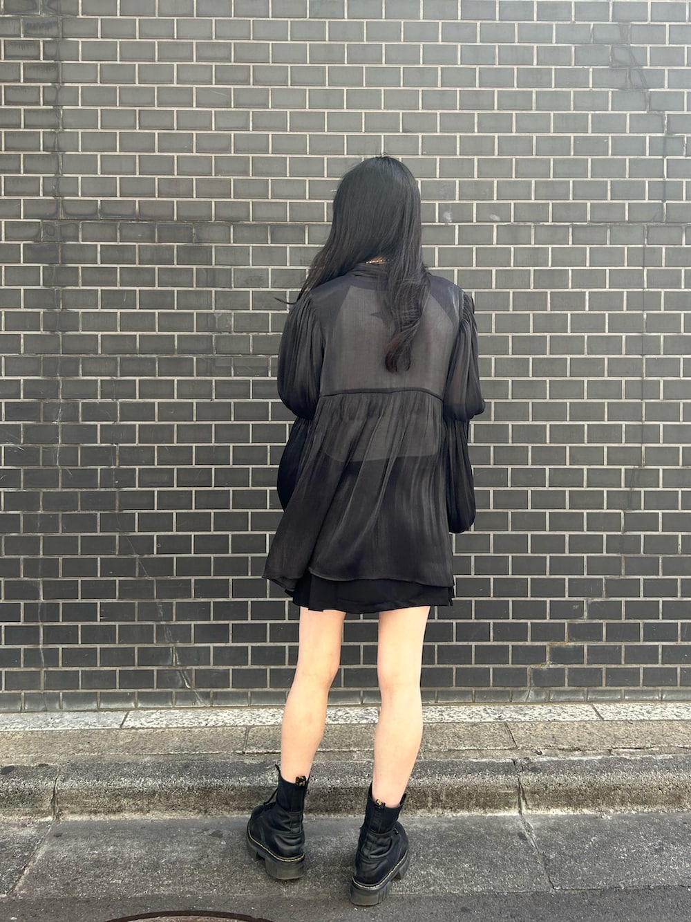 ブラック系のシャツ/ブラウス、ホワイト系のニット/セーター、ブラック系のスカートを着用したレディースの春コーディネートの3枚目の写真