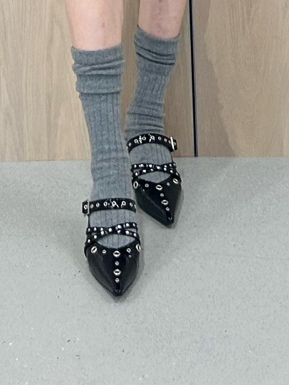 グレー系のニット/セーター、ブラック系のワンピース、ブラック系のパンプスを着用したレディースの春コーディネートの7枚目の写真