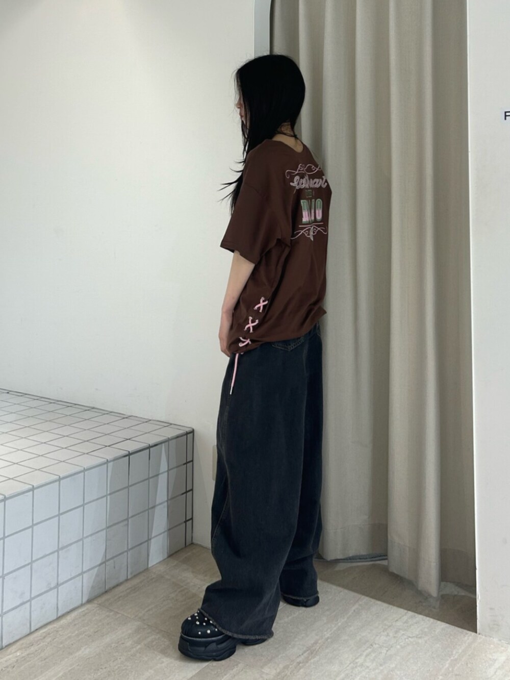 ブラック系のサンダル、ブラック系のデニムパンツ、ブラウン系のワンピースを着用したレディースの夏コーディネートの3枚目の写真