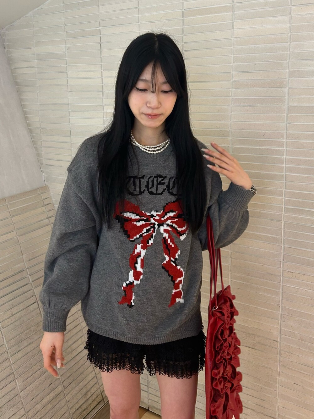 ゴールド系のパンプス、ブラック系のその他パンツ、レッド系のトートバッグを着用したレディースの冬コーディネートの4枚目の写真