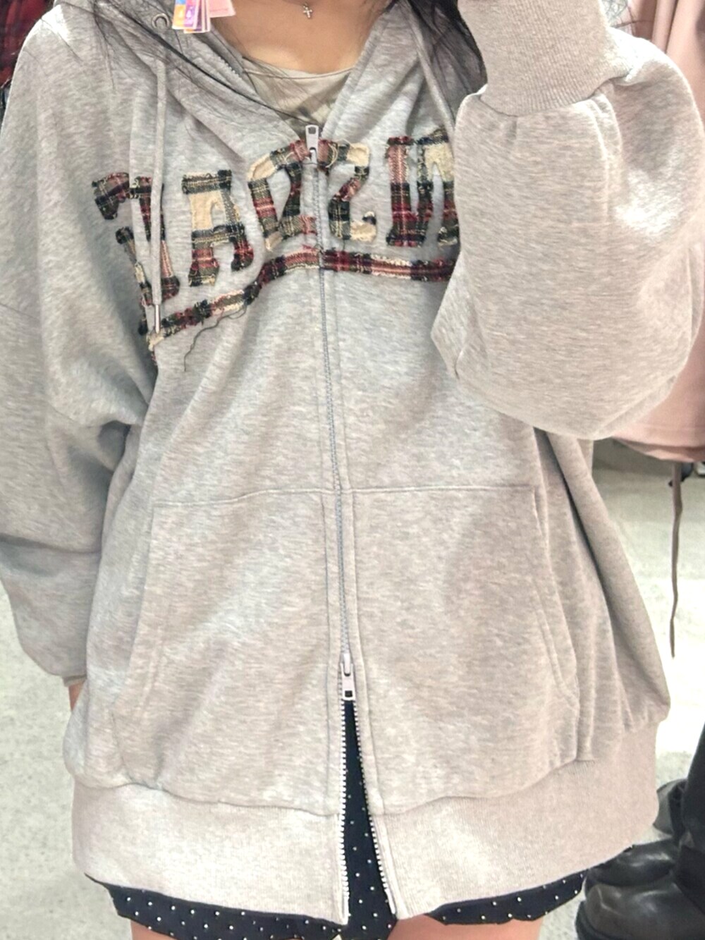 ブラック系のブーツ、グレー系のパーカー、ブラック系のスカートを着用したレディースの秋コーディネートの5枚目の写真