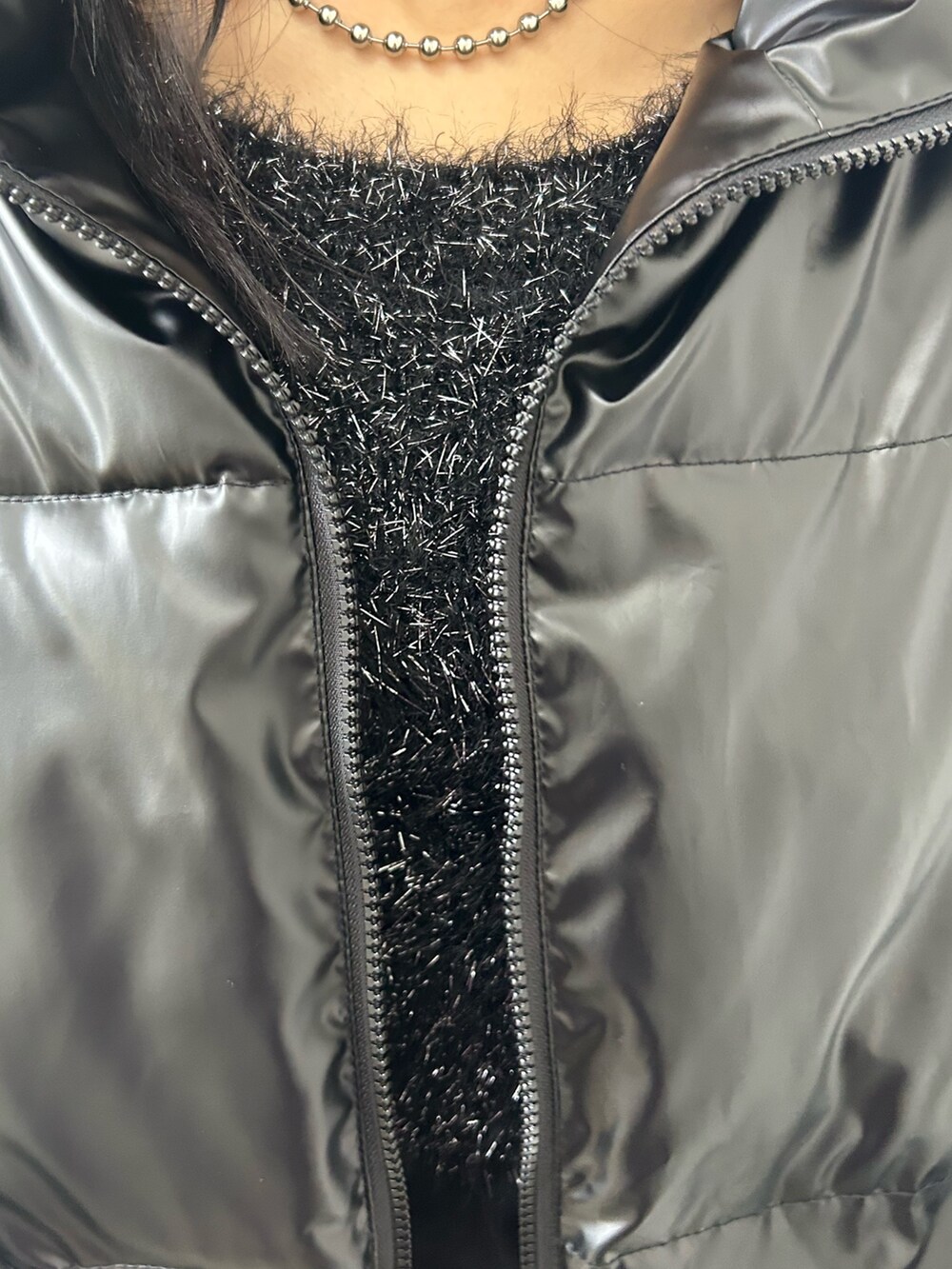 ブラック系のダウンジャケット/コート、ブラック系のニット/セーター、ブラック系のデニムスカートを着用したレディースの冬コーディネートの4枚目の写真