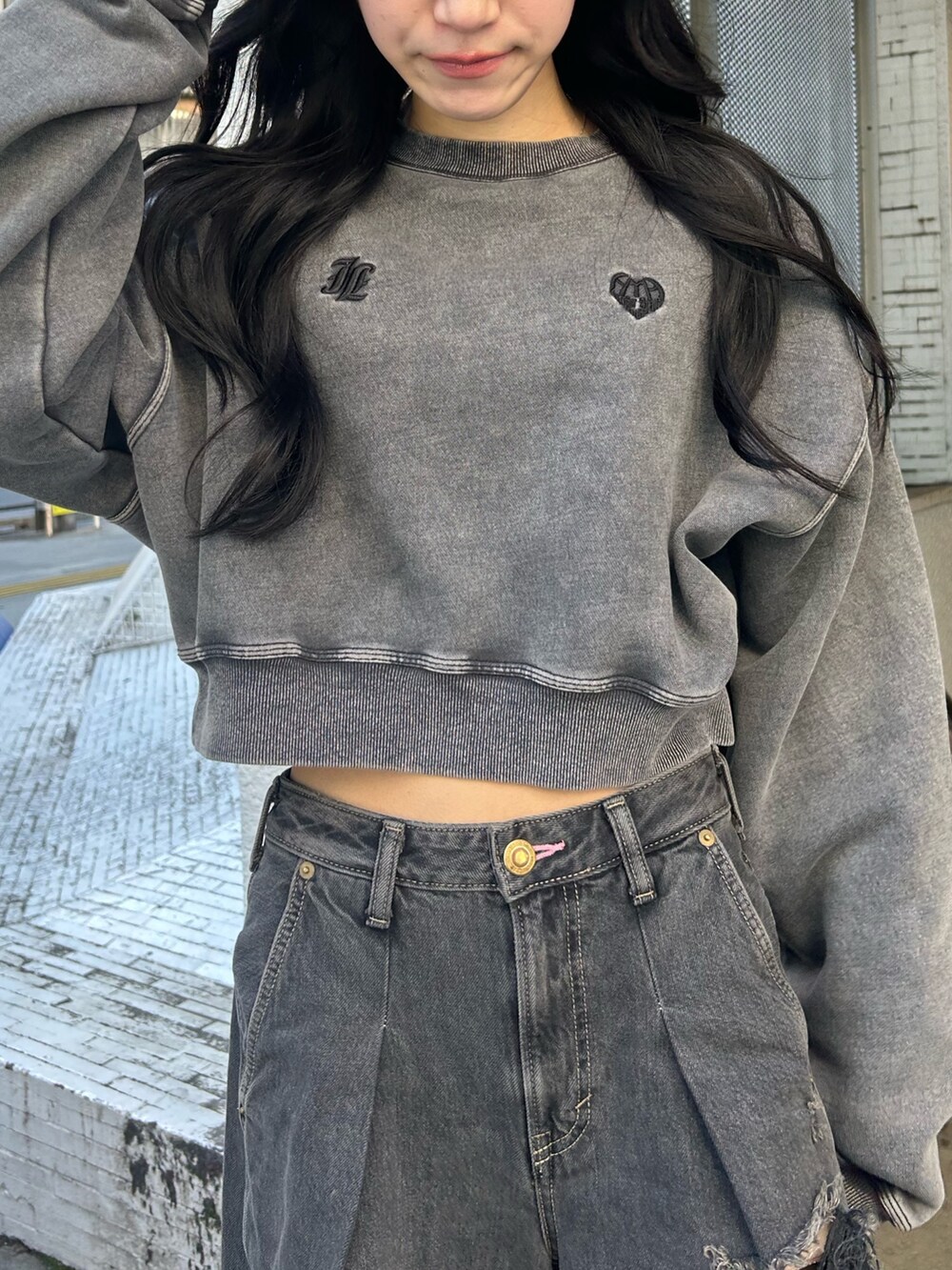 ブラック系のデニムパンツ、ブラック系のスウェット、ブラック系のパンプスを着用したレディースの冬コーディネートの4枚目の写真