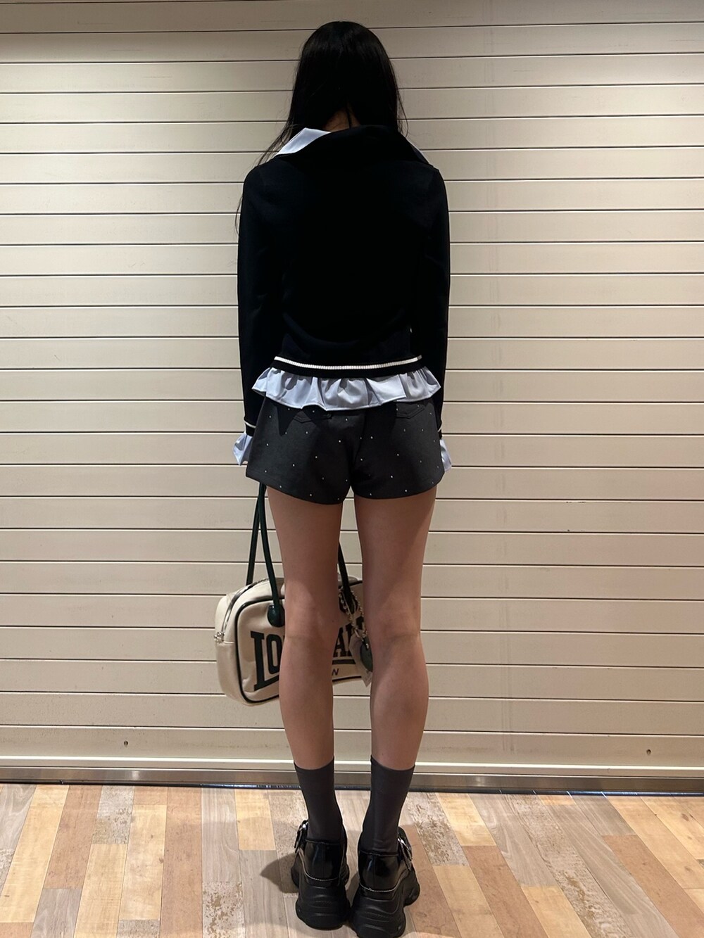 グレー系のその他パンツ、ブラック系のニット/セーター、ホワイト系のボストンバッグを着用したレディースの秋コーディネートの3枚目の写真