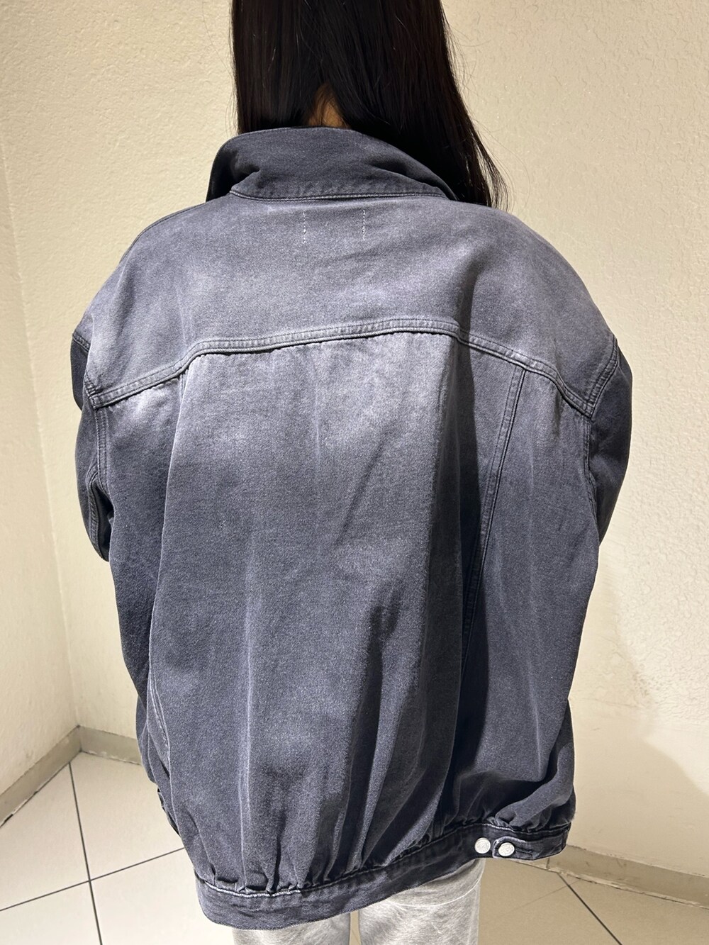 ブラック系のデニムジャケット、ブラック系のシャツ/ブラウス、グレー系のスウェットパンツを着用したレディースの春コーディネートの6枚目の写真