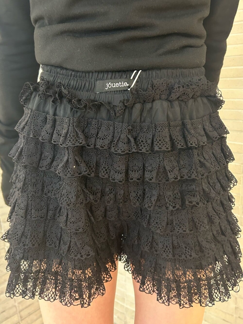 ブラック系のその他パンツ、ブラック系のニット/セーター、ブラック系のブーツを着用したレディースの冬コーディネートの6枚目の写真
