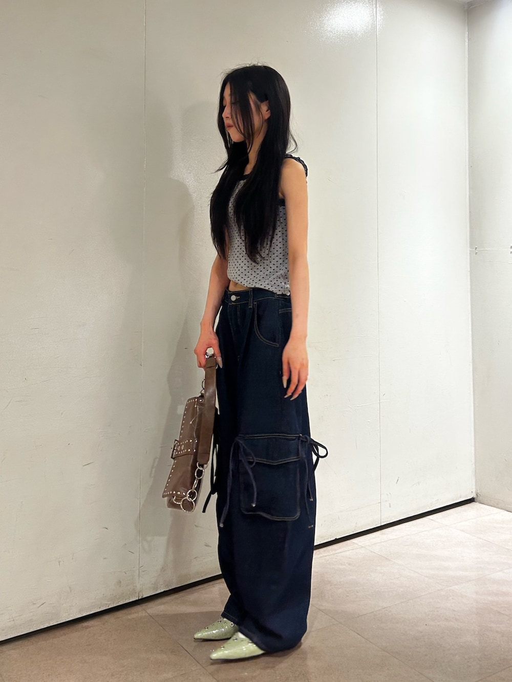 グリーン系のパンプス、グレー系のタンクトップ、ブルー系のデニムパンツを着用したレディースの夏コーディネートの2枚目の写真