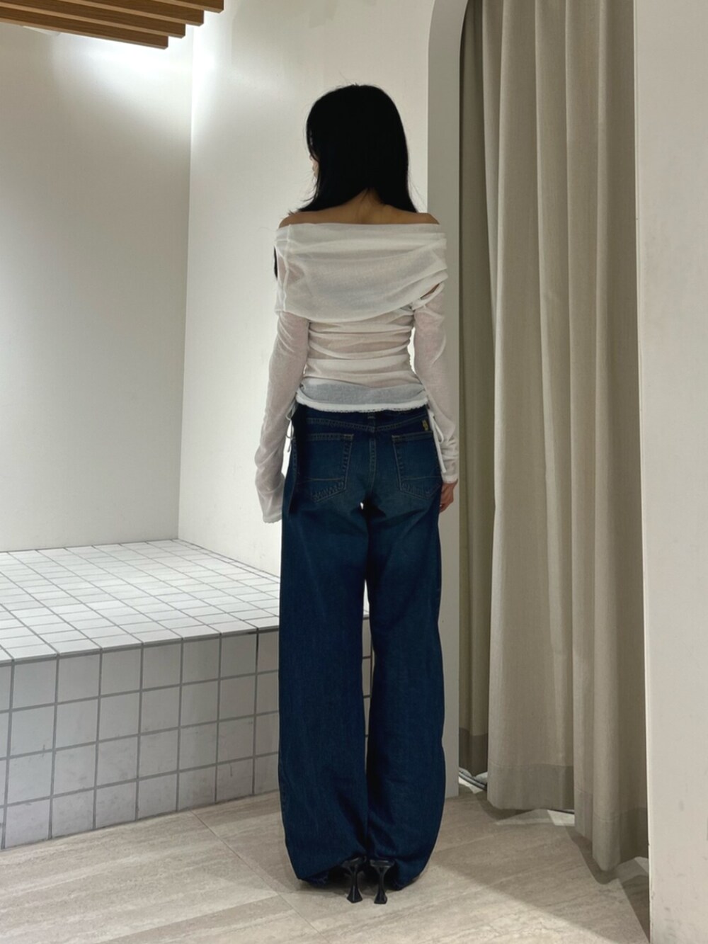 ブラック系のパンプス、ブルー系のデニムパンツ、ホワイト系のTシャツ/カットソーを着用したレディースの秋コーディネートの3枚目の写真