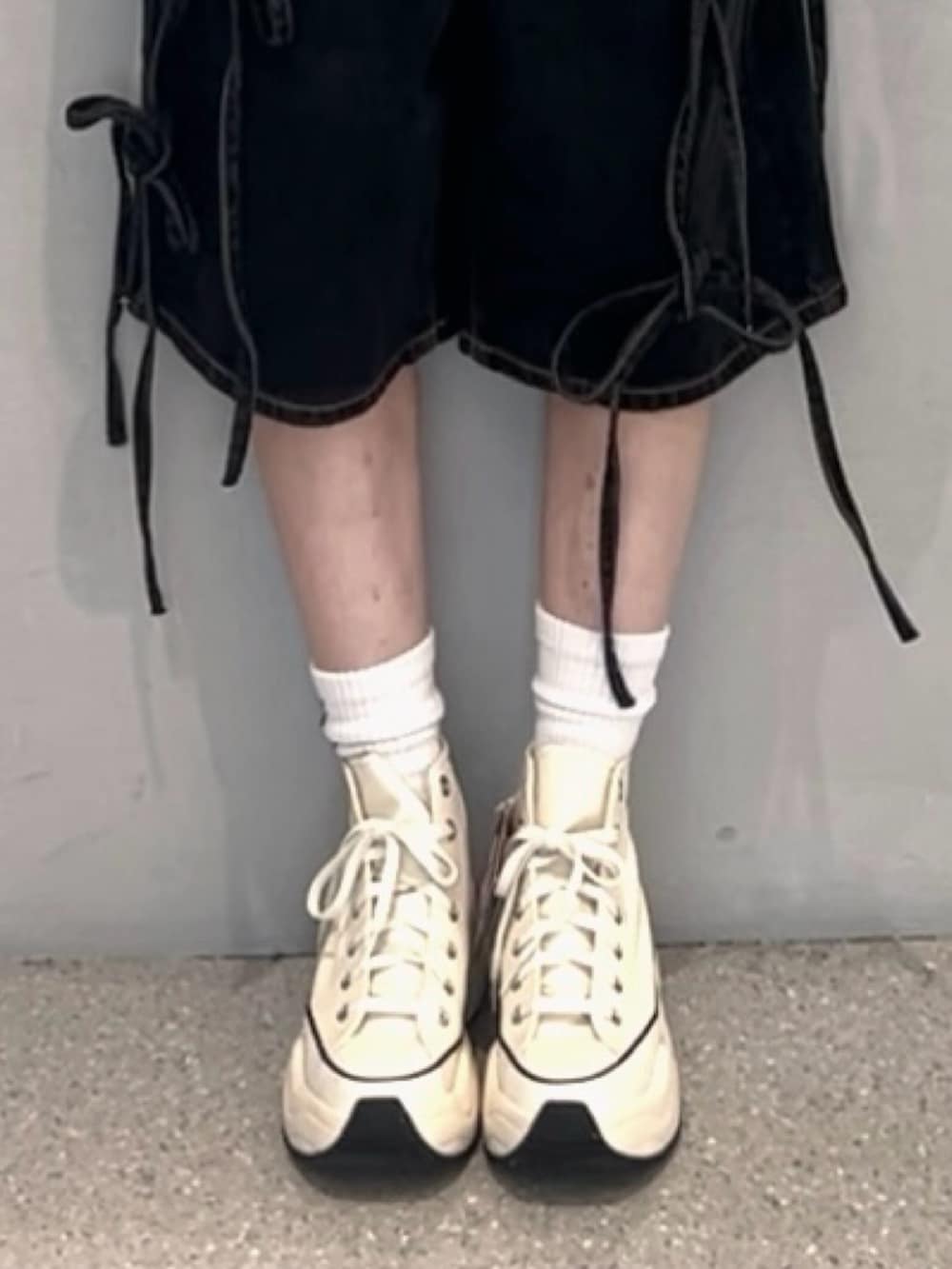 ブラック系のデニムパンツ、ホワイト系のアンサンブル、ホワイト系のスニーカーを着用したレディースの春コーディネートの8枚目の写真