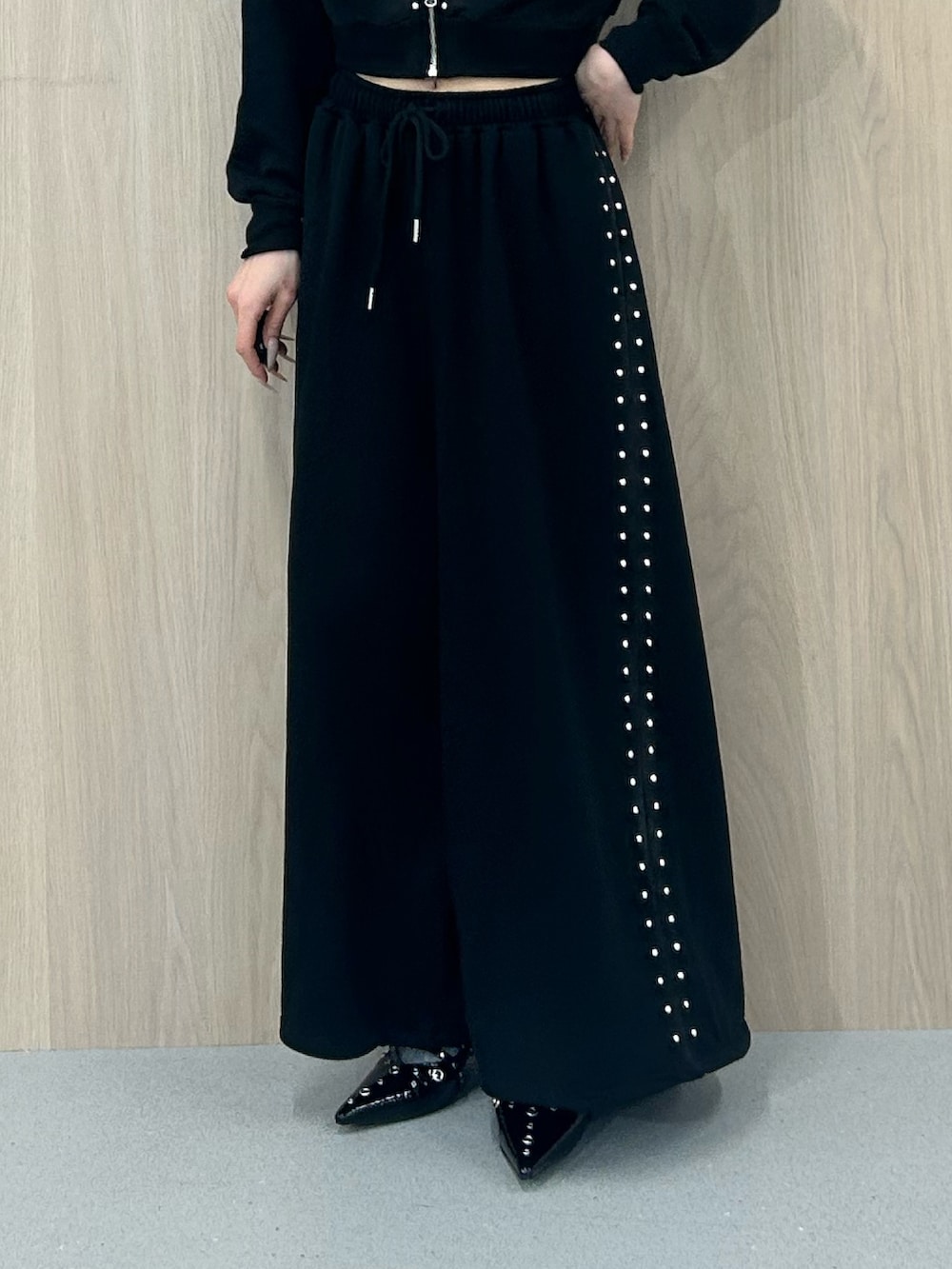 ブラック系のパーカー、ブラック系のスウェットパンツ、ブラック系のパンプスを着用したレディースの春コーディネートの7枚目の写真