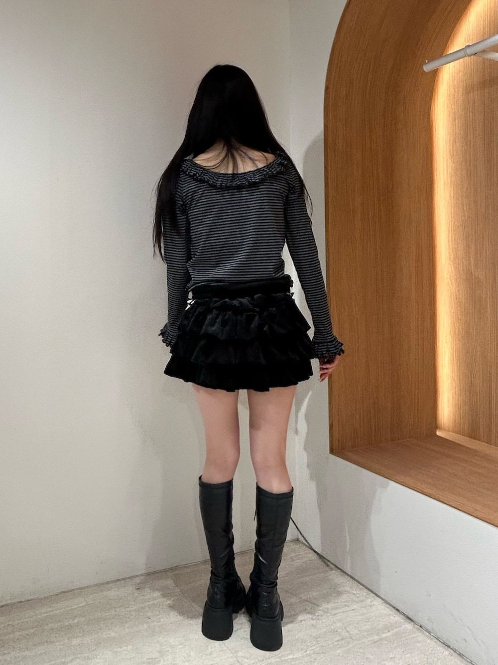 ブラック系のスカート、ブラック系のブーツ、ブラック系のTシャツ/カットソーを着用したレディースの秋コーディネートの3枚目の写真